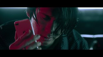 Movie still from “Adverse” (2020), directed by Brian A. Metcalf – A man is looking at his cell phone in the dark; Extreme Close Up shot, Low angle