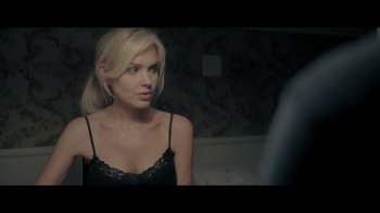 Movie still from “Adverse” (2020), directed by Brian A. Metcalf – A woman in a black top looking at a mirror; Close Up shot, Over the shoulder angle