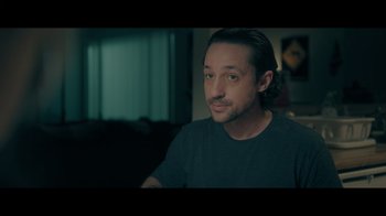 Movie still from “Adverse” (2020), directed by Brian A. Metcalf – A person sitting in front of a window; Close Up shot, Over the shoulder angle