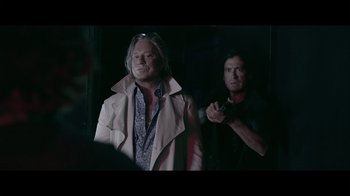 Movie still from “Adverse” (2020), directed by Brian A. Metcalf – Two men standing next to each other in a dark room; Medium shot, Over the shoulder angle