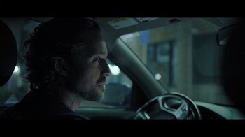 Movie still from “Adverse” (2020), directed by Brian A. Metcalf – A person in a car at night; Close Up shot, Over the shoulder angle