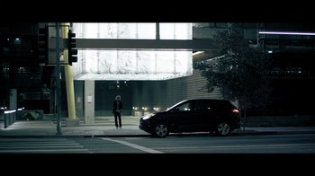 Movie still from “Adverse” (2020), directed by Brian A. Metcalf – A man standing on the side of the street next to a car; Wide shot, Low angle