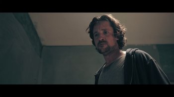 Movie still from “Adverse” (2020), directed by Brian A. Metcalf – A person with a beard looking at the camera; Close Up shot, Low angle