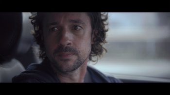 Movie still from “Adverse” (2020), directed by Brian A. Metcalf – A person with curly hair and a beard; Close Up shot, Over the shoulder angle