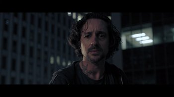 Movie still from “Adverse” (2020), directed by Brian A. Metcalf – A person wearing a shirt; Close Up shot, Low angle