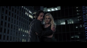 Movie still from “Adverse” (2020), directed by Brian A. Metcalf – A man and a woman standing next to each other in front of a building; Medium shot, Over the shoulder angle