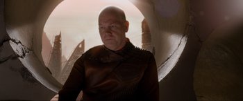 Movie still from “After Earth” (2013), directed by M. Night Shyamalan – A bald man wearing a brown leather jacket; Medium shot, Over the shoulder angle