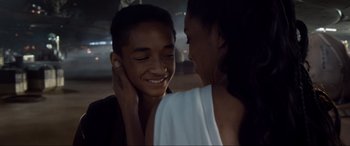 Movie still from “After Earth” (2013), directed by M. Night Shyamalan – A young man and a young woman smiling at each other; Close Up shot, Over the shoulder angle
