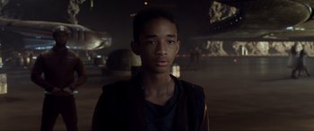 Movie still from “After Earth” (2013), directed by M. Night Shyamalan – A young man is standing in a dark room; Medium shot, Over the shoulder angle