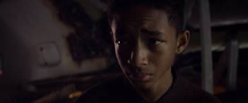 Movie still from “After Earth” (2013), directed by M. Night Shyamalan – A young boy with a dark background looking at the camera; Close Up shot, Low angle