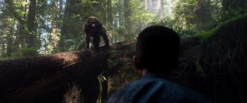 Movie still from “After Earth” (2013), directed by M. Night Shyamalan – A man looking at a bear on a log in the woods; Wide shot, Over the shoulder angle