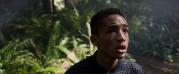 Movie still from “After Earth” (2013), directed by M. Night Shyamalan – A young man is looking into the distance in the woods; Close Up shot, High angle