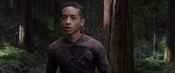 Movie still from “After Earth” (2013), directed by M. Night Shyamalan – A young man in a body suit standing in front of a tree; Close Up shot, Over the shoulder angle