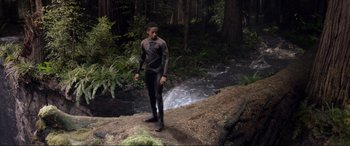 Movie still from “After Earth” (2013), directed by M. Night Shyamalan – A man standing on top of a rock near a river; Wide shot, Low angle
