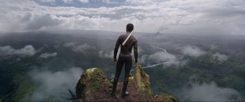 Movie still from “After Earth” (2013), directed by M. Night Shyamalan – A man standing on top of a mountain looking at the sky; Extreme Wide shot, Low angle