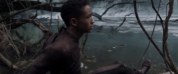 Movie still from “After Earth” (2013), directed by M. Night Shyamalan – A young boy sitting in a body of water; Medium shot, High angle