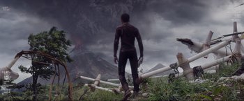 Movie still from “After Earth” (2013), directed by M. Night Shyamalan – A man standing in the grass near a mountain; Extreme Wide shot, High angle