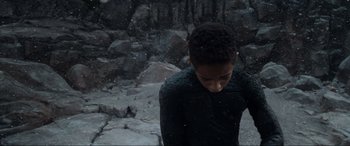 Movie still from “After Earth” (2013), directed by M. Night Shyamalan – A young man standing in the snow looking down at the ground; Close Up shot, High angle