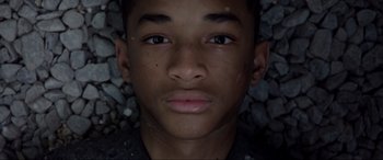 Movie still from “After Earth” (2013), directed by M. Night Shyamalan – A young man's face on some rocks; Close Up shot, Overhead angle