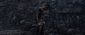 Movie still from “After Earth” (2013), directed by M. Night Shyamalan – A man holding a hammer while standing in the snow; Medium shot, Low angle