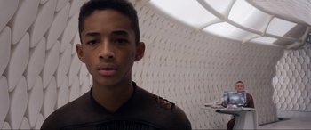 Movie still from “After Earth” (2013), directed by M. Night Shyamalan – A young man with a black shirt and a white wall in the background; Close Up shot, High angle