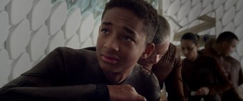 Movie still from “After Earth” (2013), directed by M. Night Shyamalan – A young man is looking at the camera while another man watches; Close Up shot, High angle