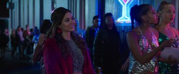 Movie still from “Afterlife of the Party” (2021), directed by Stephen Herek – A beautiful woman in a red coat standing next to a man; Medium shot, Over the shoulder angle