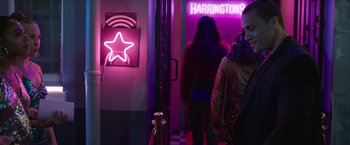 Movie still from “Afterlife of the Party” (2021), directed by Stephen Herek – Two women are standing in front of a neon sign; Medium shot, Over the shoulder angle