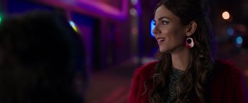 Movie still from “Afterlife of the Party” (2021), directed by Stephen Herek – A beautiful woman in a red jacket smiling; Close Up shot, Over the shoulder angle