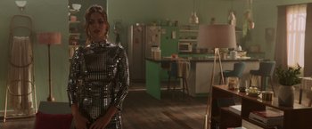 Movie still from “Afterlife of the Party” (2021), directed by Stephen Herek – A woman standing in front of a kitchen with green walls; Medium shot, Over the shoulder angle