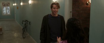 Movie still from “Afterlife of the Party” (2021), directed by Stephen Herek – A man and a woman are talking in a hallway; Medium shot, Over the shoulder angle