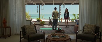 Movie still from “Afterlife of the Party” (2021), directed by Stephen Herek – A man and a woman standing in front of the ocean; Wide shot, High angle