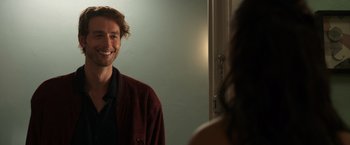 Movie still from “Afterlife of the Party” (2021), directed by Stephen Herek – A man standing in front of a mirror and smiling; Close Up shot, Over the shoulder angle