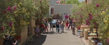 Movie still from “Afterlife of the Party” (2021), directed by Stephen Herek – A group of people standing on the side of a road; Extreme Wide shot, High angle