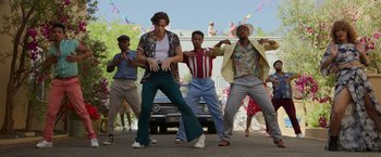 Movie still from “Afterlife of the Party” (2021), directed by Stephen Herek – A group of men standing next to each other on the street; Wide shot, Low angle