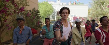 Movie still from “Afterlife of the Party” (2021), directed by Stephen Herek – A group of people walking down a street; Medium shot, Over the shoulder angle