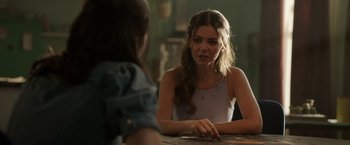 Movie still from “Afterlife of the Party” (2021), directed by Stephen Herek – A woman sitting in front of another woman at a table; Close Up shot, Over the shoulder angle