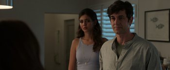 Movie still from “Afterlife of the Party” (2021), directed by Stephen Herek – A man and a woman standing next to each other in a room; Medium shot, Over the shoulder angle