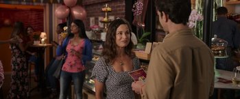 Movie still from “Afterlife of the Party” (2021), directed by Stephen Herek – A woman is talking to a man in a store; Medium shot, Over the shoulder angle