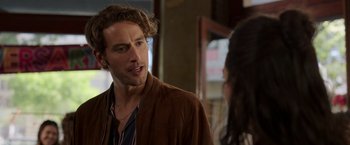 Movie still from “Afterlife of the Party” (2021), directed by Stephen Herek – A man with long hair talking to a woman; Close Up shot, Over the shoulder angle