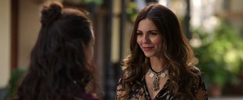 Movie still from “Afterlife of the Party” (2021), directed by Stephen Herek – A beautiful woman wearing a necklace standing next to another woman; Close Up shot, Over the shoulder angle