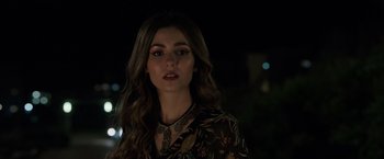 Movie still from “Afterlife of the Party” (2021), directed by Stephen Herek – A beautiful young lady with long brown hair wearing jewelry; Close Up shot, Over the shoulder angle