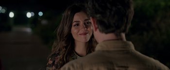 Movie still from “Afterlife of the Party” (2021), directed by Stephen Herek – A woman smiles at a man in front of a tree; Close Up shot, Over the shoulder angle