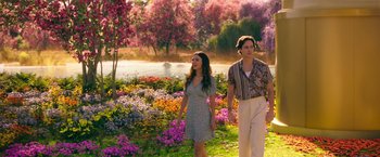 Movie still from “Afterlife of the Party” (2021), directed by Stephen Herek – A man and a woman walking through a field of flowers; Wide shot, High angle