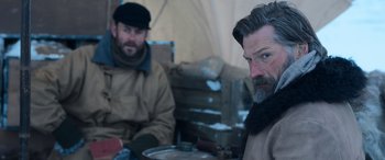 Movie still from “Against the Ice” (2022), directed by Peter Flinth – A man with a beard is sitting next to another man with a beard; Medium shot, Over the shoulder angle