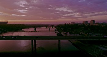 Movie still from “Agent Game” (2022), directed by Grant S. Johnson – A view of a river with a bridge in the background; Extreme Wide shot, High angle