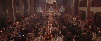 Movie still from “Air Force One” (1997), directed by Wolfgang Petersen – A large group of people sitting at a long table; Extreme Wide shot, High angle