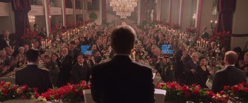 Movie still from “Air Force One” (1997), directed by Wolfgang Petersen – A crowd of people sitting at a table with candles; Wide shot, High angle