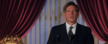 Movie still from “Air Force One” (1997), directed by Wolfgang Petersen – A person wearing a suit and tie; Close Up shot, Low angle