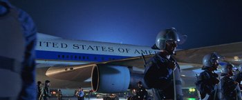 Movie still from “Air Force One” (1997), directed by Wolfgang Petersen – A man standing in front of an air plane; Medium shot, Low angle